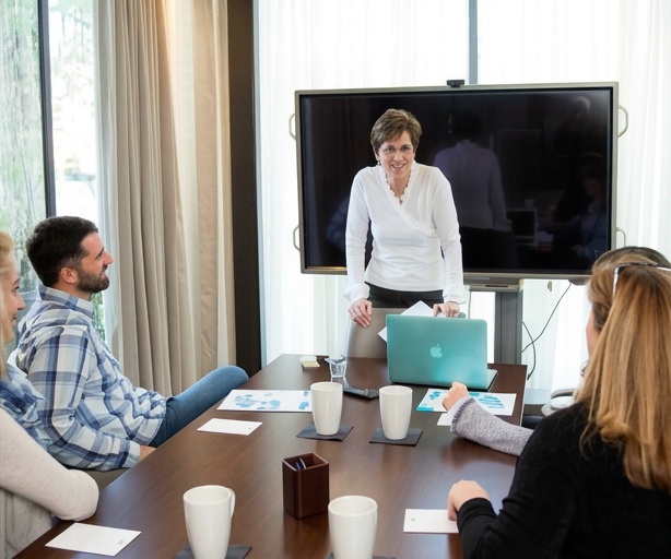 Randi leading a discussion with a group around a meeting table